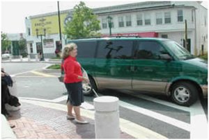 Visually impaired individual prepares to cross